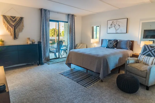 a bedroom with a bed and a painting on the wall