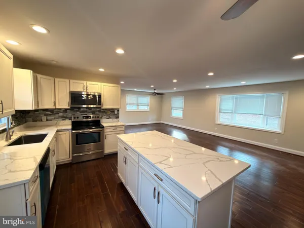 a kitchen with stainless steel appliances granite countertop refrigerator sink and stove
