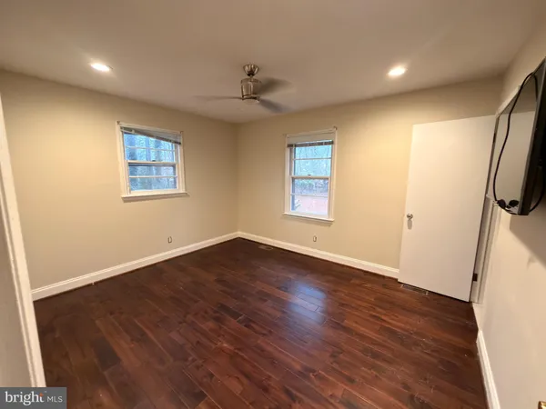 an empty room with wooden floor and window