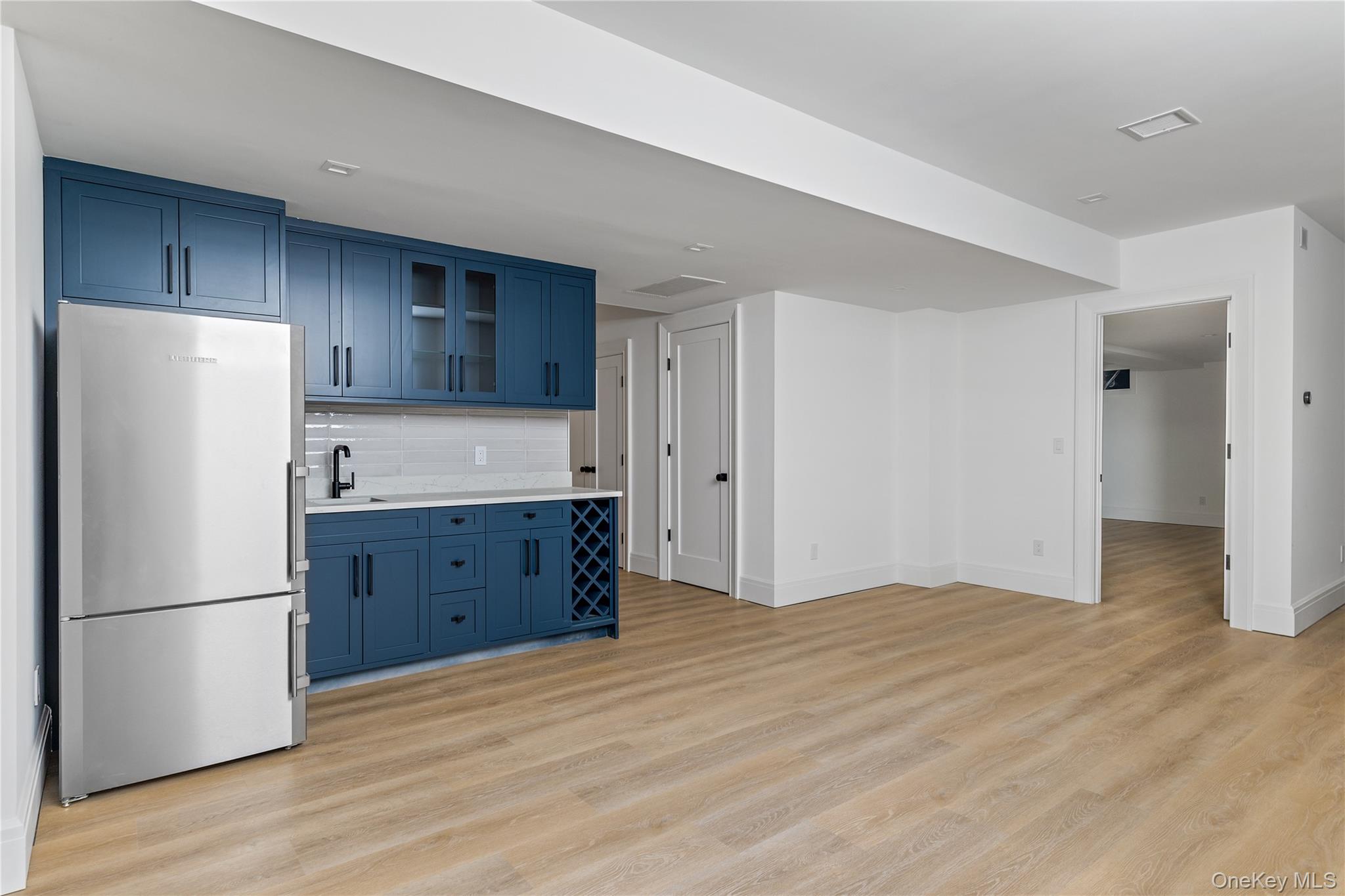 42 Mamaroneck Road Scarsdale, NY 10583 - Photo 39 of 47 The finished lower level includes a spacious recreation room with a beautifully appointed kitchenette featuring custom cabinetry, a full-size refrigerator, and sink—perfect for entertaining or extended guest stays.