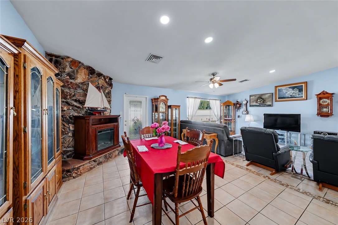 3107 Trueno Road Henderson, NV 89014 - Photo 3 of 37 A spacious common area boasts ceramic tile flooring, a cozy fireplace, and bright recessed lighting.