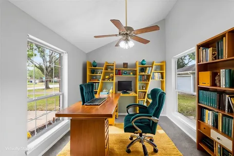 a view of a workspace with furniture and a book shelf