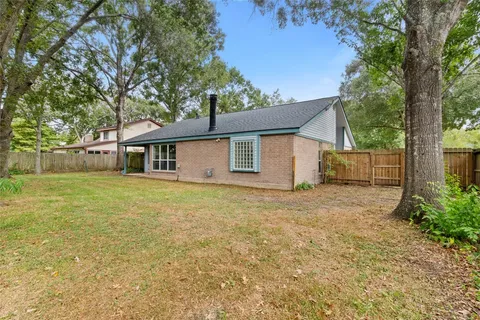 a front view of a house with a garden and trees