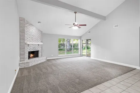 a view of an empty room with a fireplace and a window