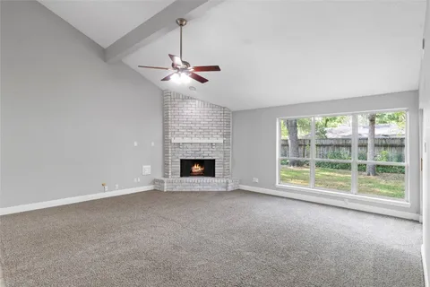 a view of an empty room with a fireplace and a window