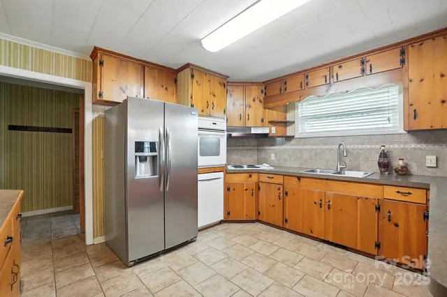 a kitchen with stainless steel appliances granite countertop a refrigerator and a sink