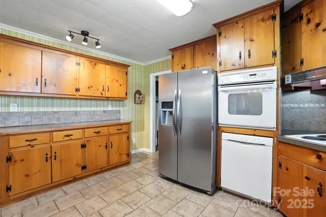 a kitchen with stainless steel appliances granite countertop a refrigerator a stove and a sink with cabinets