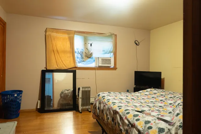 a bedroom with a bed and wooden floor