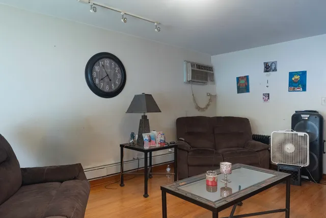 a living room with furniture a rug and a wall painting