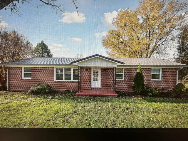 a front view of house with yard and trees around