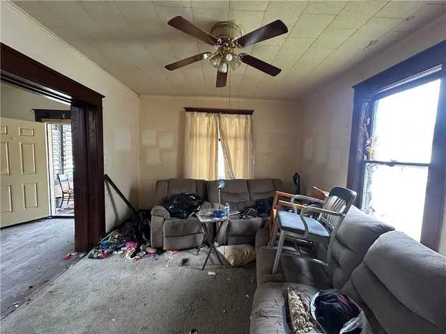 a living room with furniture a ceiling fan and a window