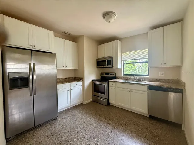 an empty room with fan and windows
