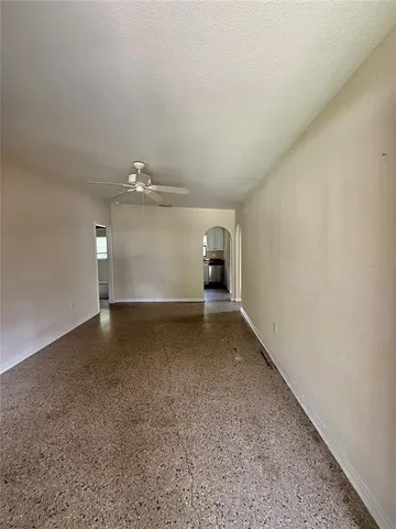 an empty room with a ceiling fan and a window