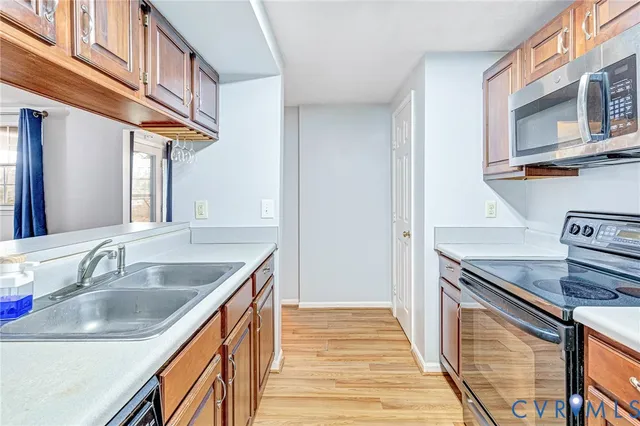 a kitchen with stainless steel appliances granite countertop a sink and dishwasher a stove top oven with wooden floor