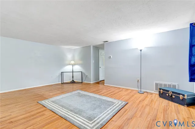 a bedroom with a bed and a lamp with wooden floor
