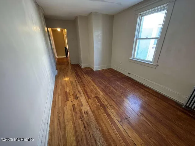 a view of a room with wooden floor and staircase