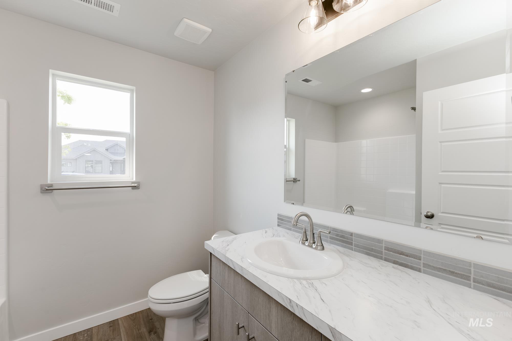 5315 Castleton Avenue Nampa, ID 83686 - Photo 13 of 19 Full bathroom featuring dark wood finished floors, vanity, and a shower