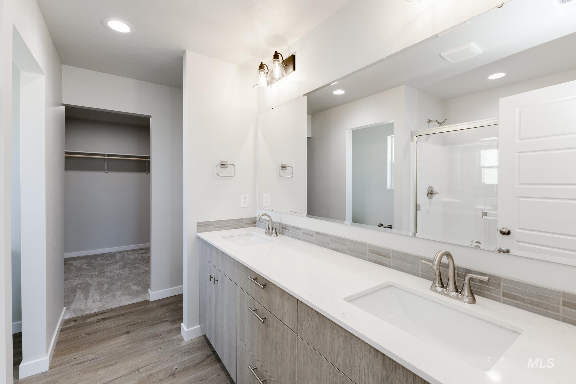 5315 Castleton Avenue Nampa, ID 83686 - Photo 18 of 19 Bathroom featuring double vanity, recessed lighting, a shower stall, light wood-style floors, and a spacious closet