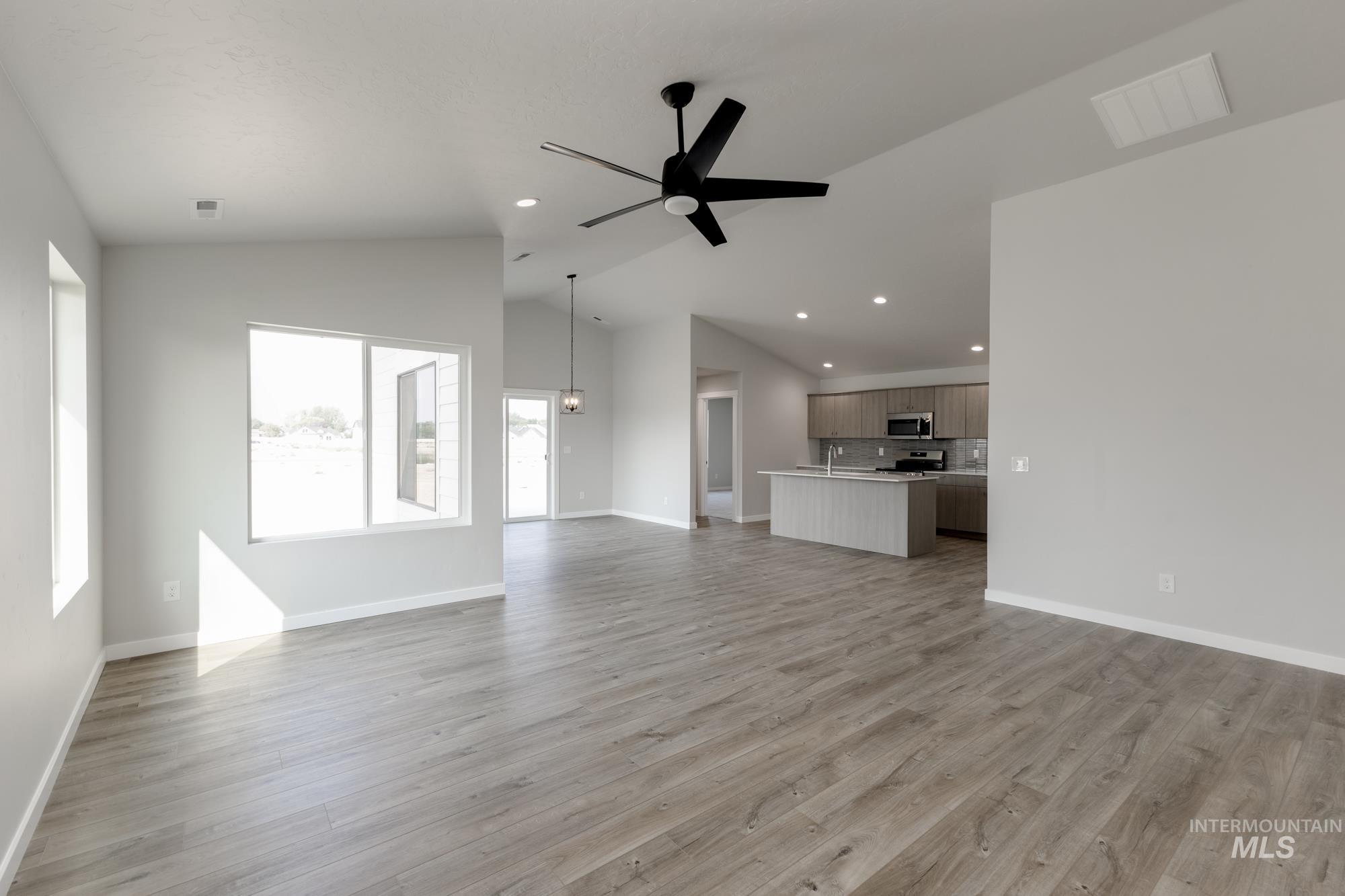 5315 Castleton Avenue Nampa, ID 83686 - Photo 10 of 19 Unfurnished living room featuring ceiling fan, light wood finished floors, lofted ceiling, and recessed lighting