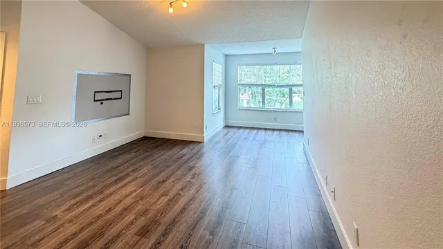 wooden floor in an empty room with a window