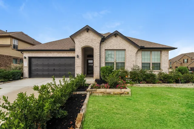 a front view of a house with a yard and garage