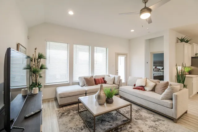 a living room with furniture potted plant and a large window