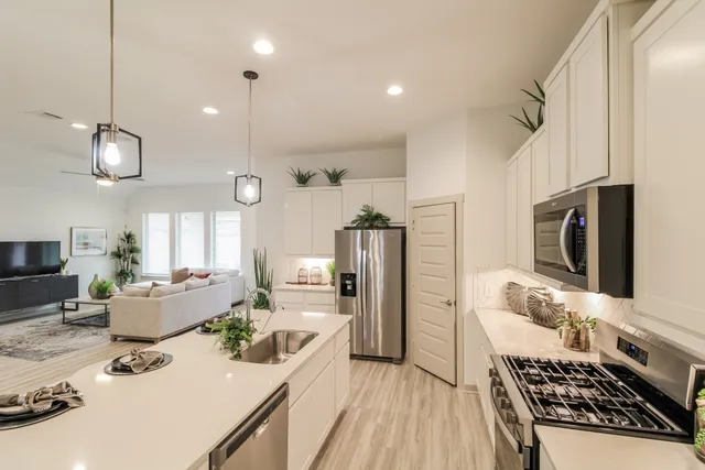 a kitchen with stainless steel appliances kitchen island granite countertop a stove refrigerator and cabinets
