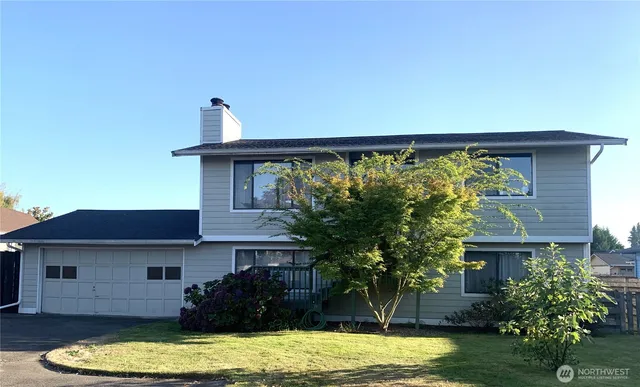 a view of a house with a yard balcony and tree