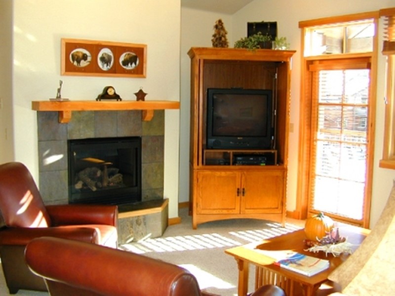 75 Snowflake Drive, Unit 836 Breckenridge, CO 80424 - Photo 5 of 14 a living room with a fireplace and a table