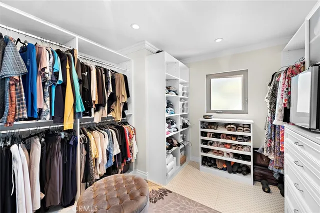 a view of walk in closet with clothes and shoes