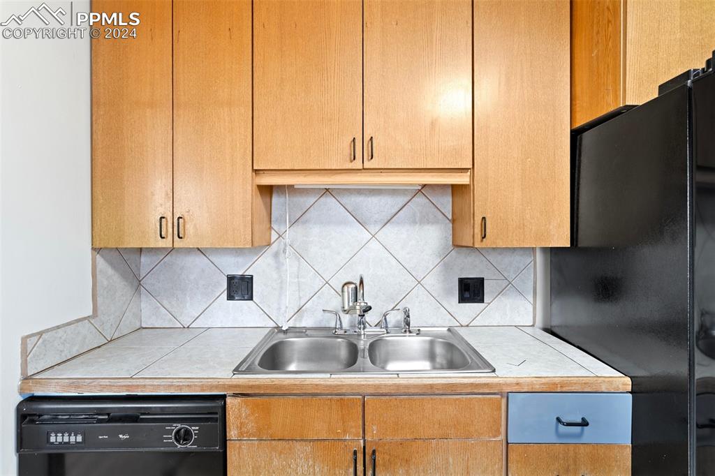928 Alexander Road Colorado Springs, CO 80909 - Photo 7 of 24 a kitchen with a sink cabinets and appliances