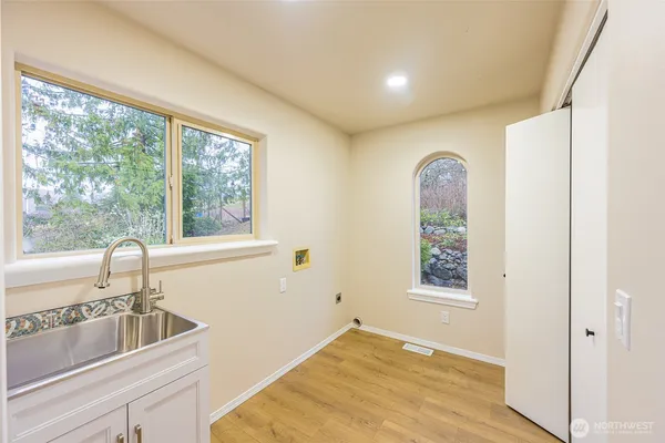 a view of a room that has a sink and dishwasher with wooden floor