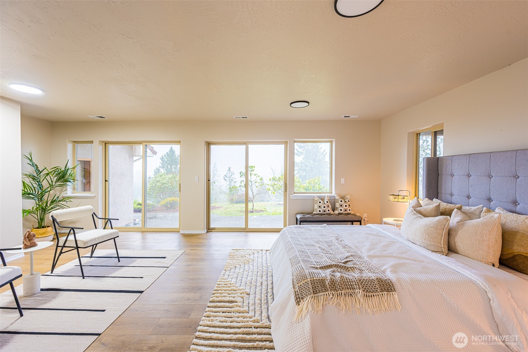 315 Quails Roost Road Sequim, WA 98382 - Photo 21 of 34 a spacious bedroom with a bed a large window and walk in closet