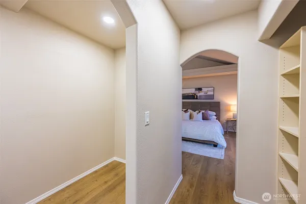 a view of a hallway with wooden floor and closet