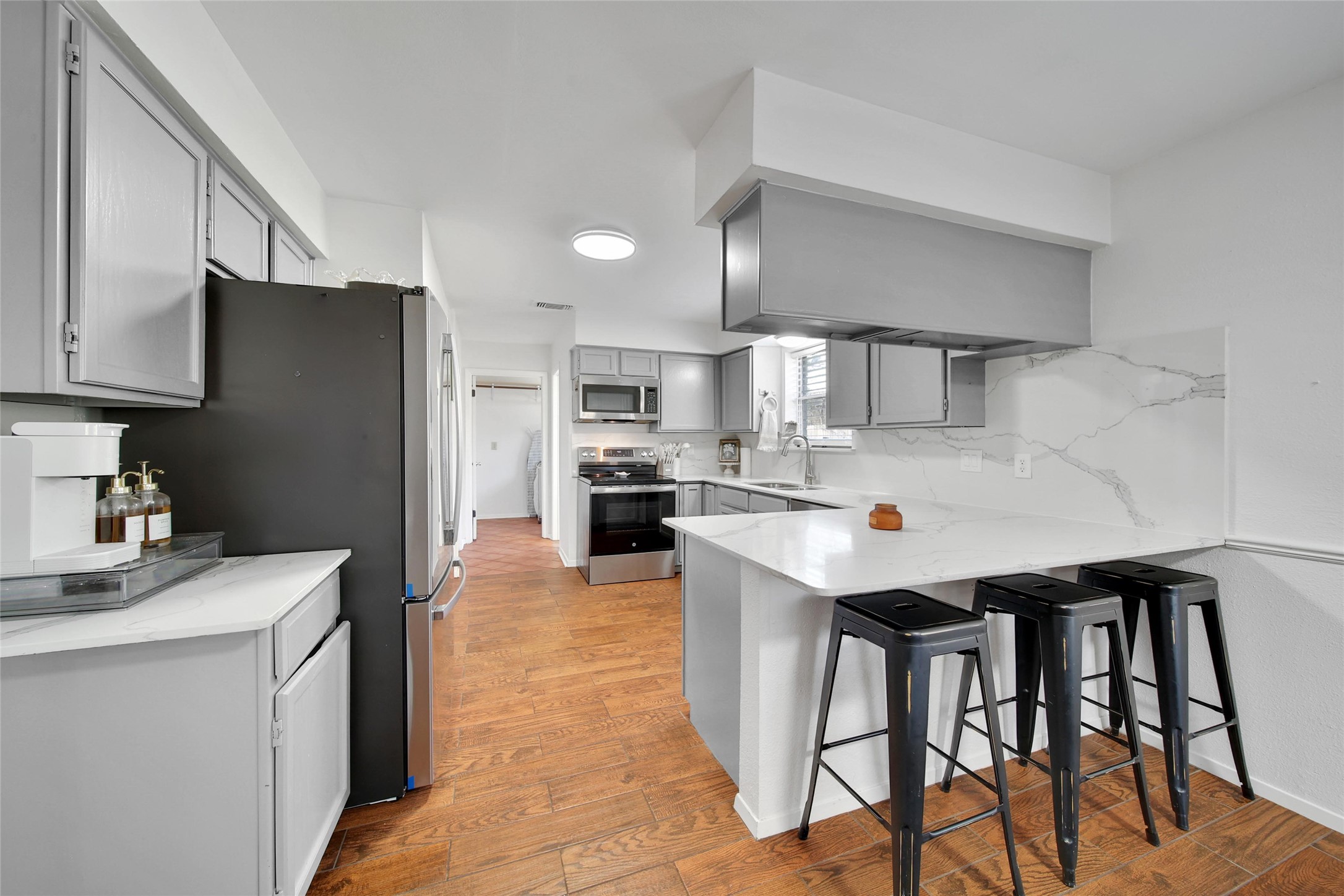 4206 Pineville Lane Spring, TX 77388 - Photo 16 of 35 a kitchen with stainless steel appliances kitchen island granite countertop a refrigerator a sink dishwasher a stove and white cabinets with wooden floor