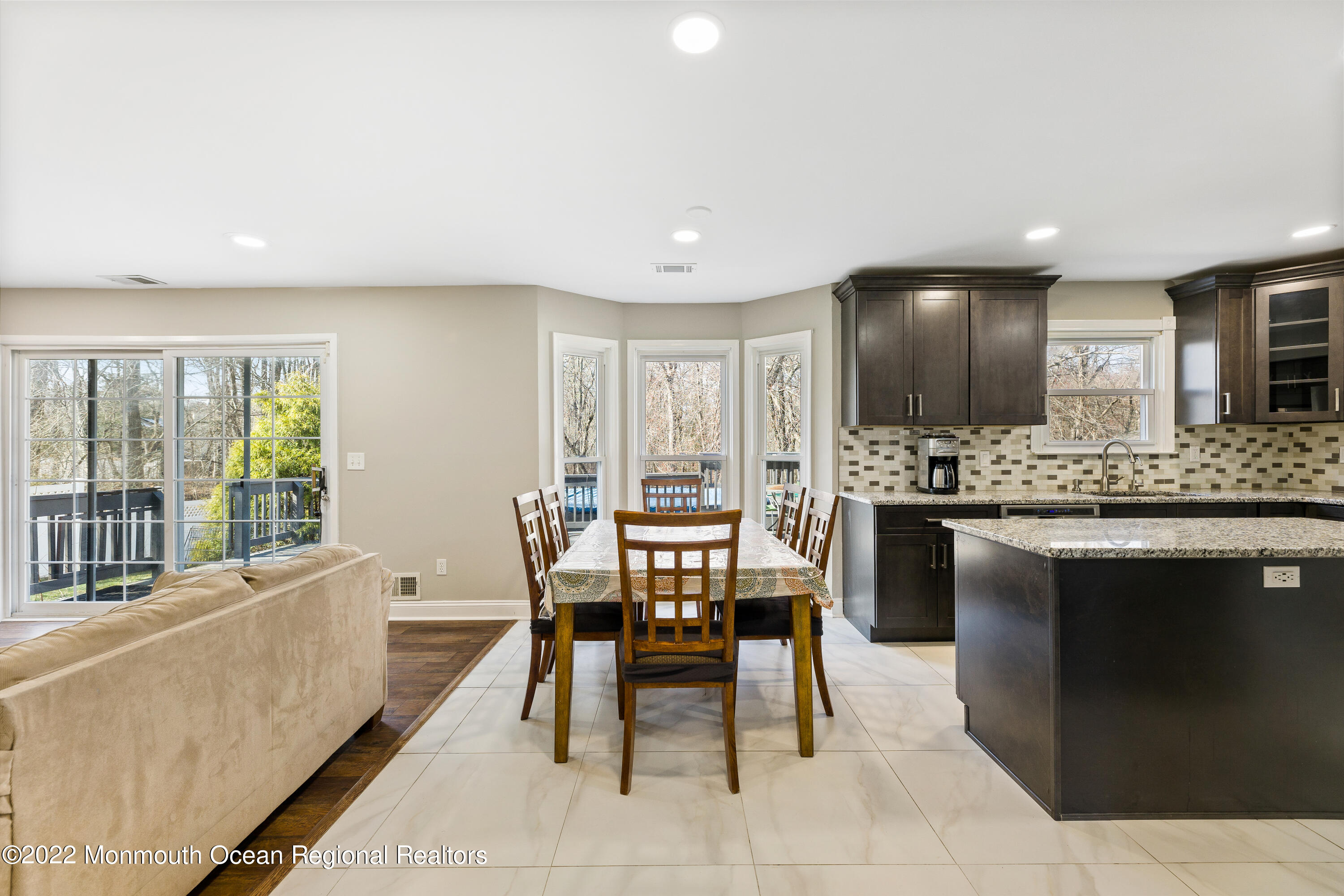 10 Reed Road Howell, NJ 07731 - Photo 13 of 32 a dining hall with stainless steel appliances kitchen island granite countertop a table and chairs in it