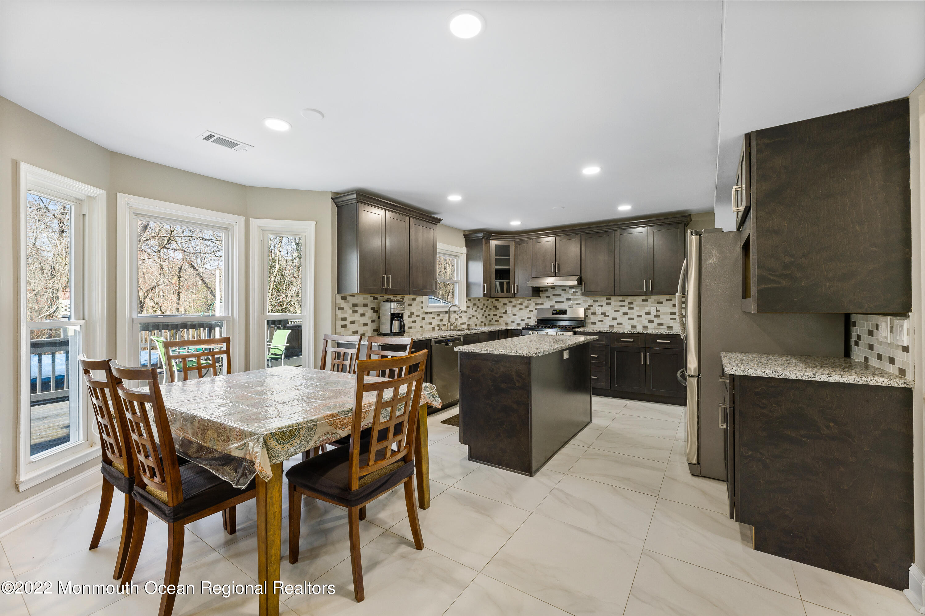 10 Reed Road Howell, NJ 07731 - Photo 14 of 32 a kitchen with kitchen island a dining table chairs stainless steel appliances and cabinets