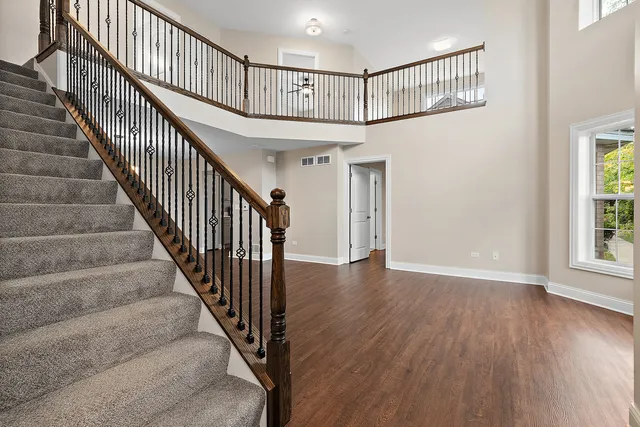 a view of staircase with wooden floor and a chandelier