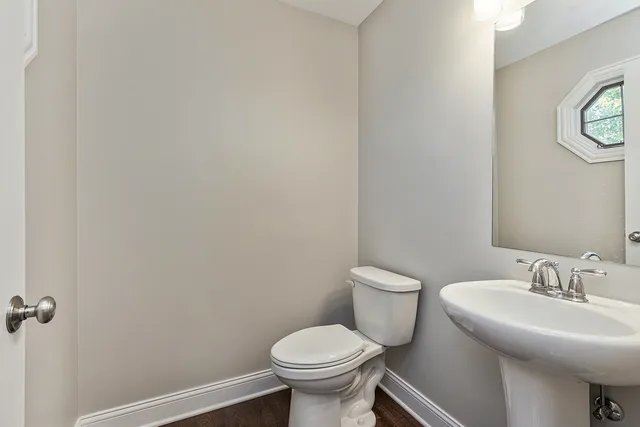 a bathroom with a toilet a sink a tub and mirror