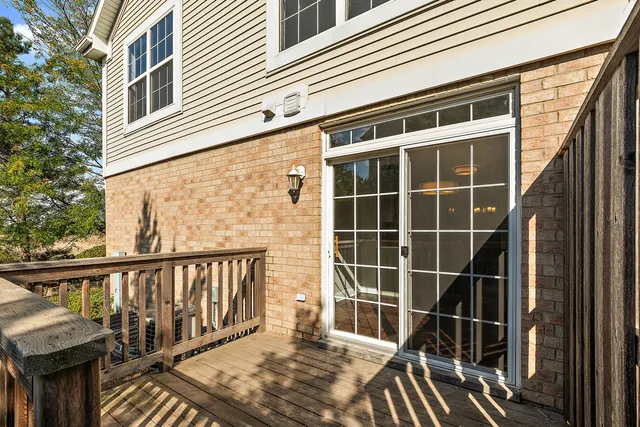 a view of balcony with wooden floor and fence and a floor to ceiling window