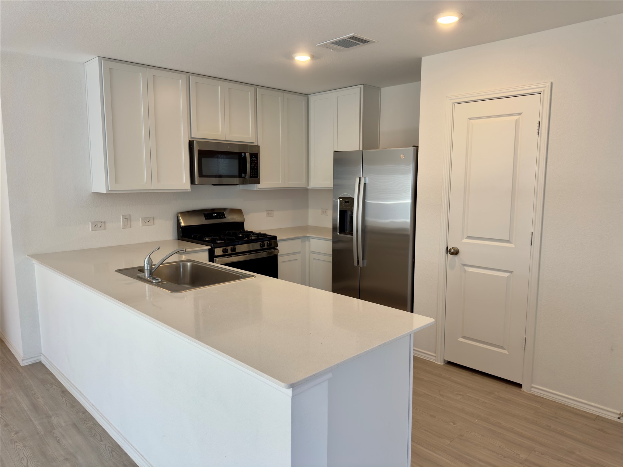 2218 Cumulus Court Lockhart, TX 78644 - Photo 11 of 35 a kitchen with stainless steel appliances a refrigerator a sink a stove a microwave and wooden cabinets