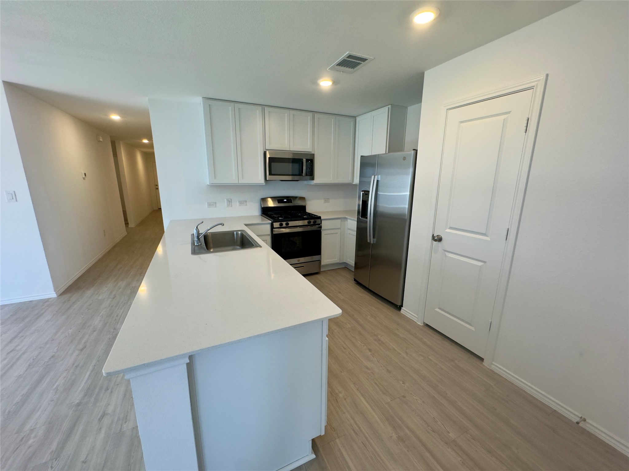 2218 Cumulus Court Lockhart, TX 78644 - Photo 12 of 35 a kitchen with a refrigerator a sink and cabinets