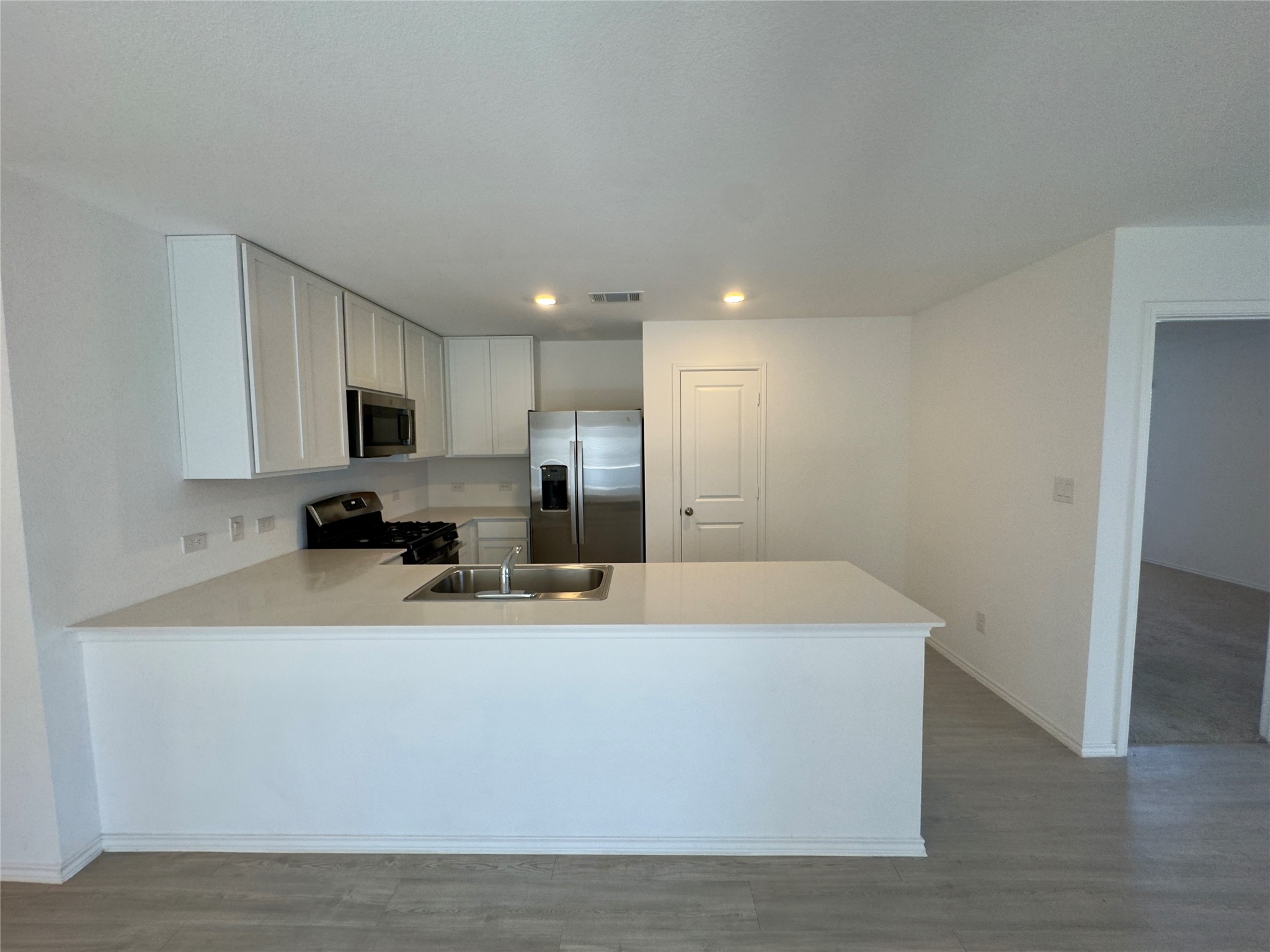 2218 Cumulus Court Lockhart, TX 78644 - Photo 13 of 35 a large white kitchen with wooden floor