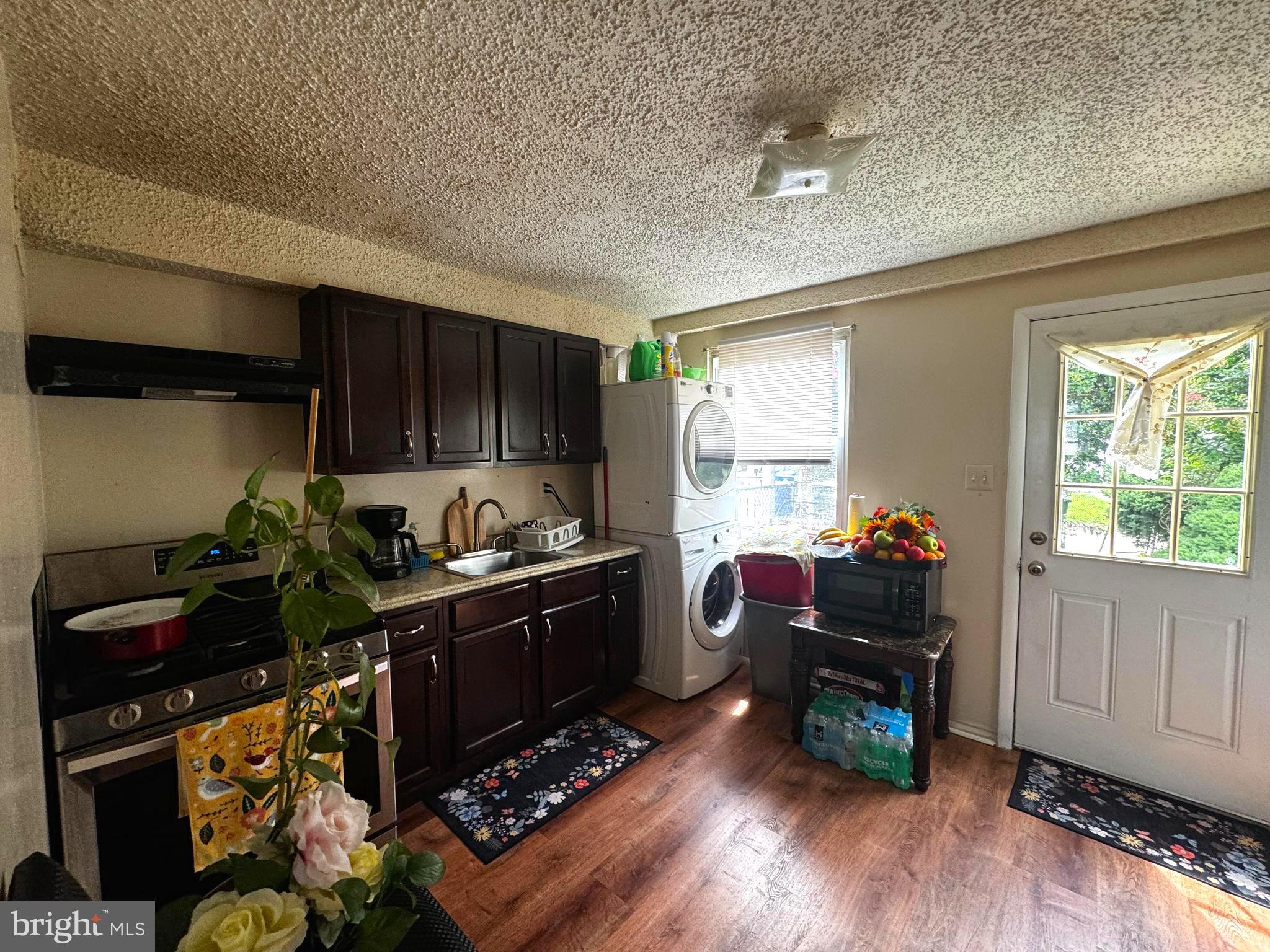 a kitchen with wooden floors appliances and cabinets