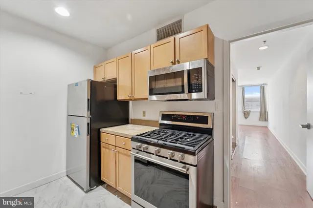a kitchen with cabinets stainless steel appliances and a counter space