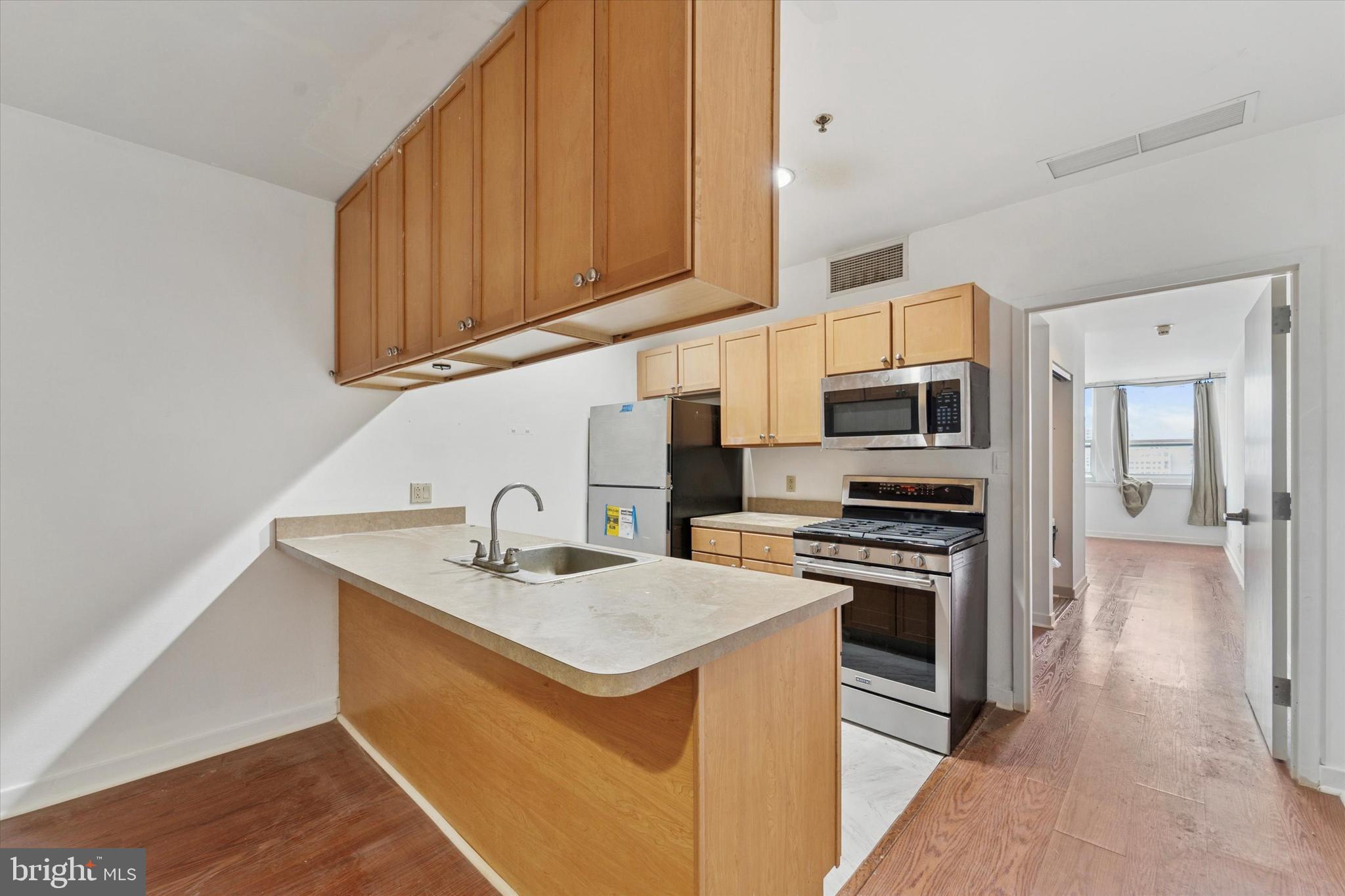 1100 Vine Street, Unit P211 Philadelphia, PA 19107 - Photo 8 of 20 a kitchen with stainless steel appliances granite countertop a sink stove and refrigerator