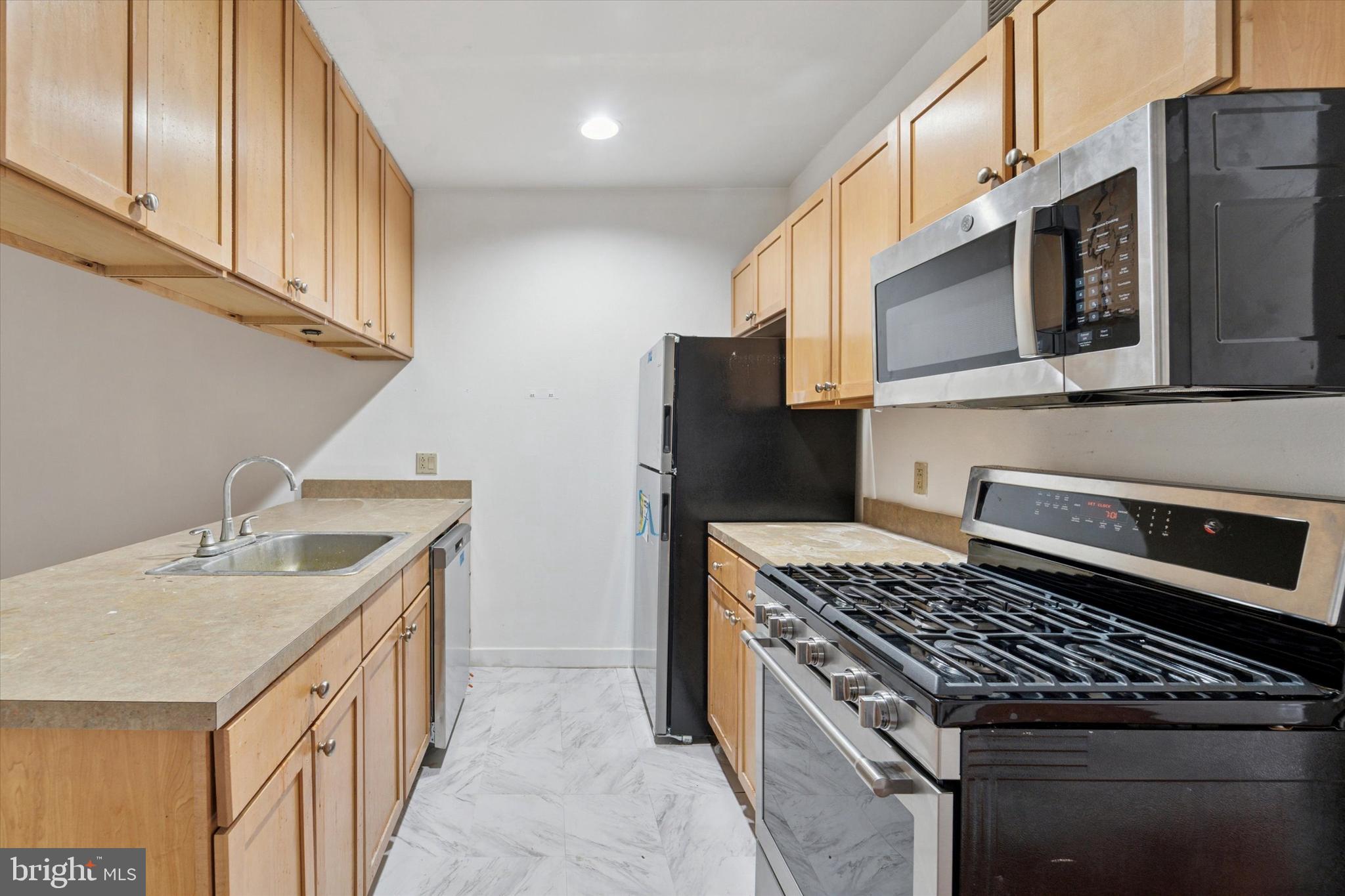 1100 Vine Street, Unit P211 Philadelphia, PA 19107 - Photo 9 of 20 a kitchen with stainless steel appliances granite countertop a sink stove and refrigerator