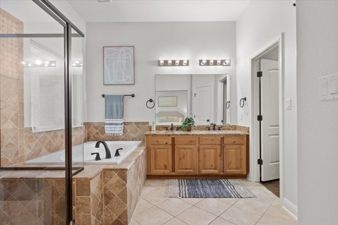 15317 Origins Lane, Unit 203 Austin, TX 78734 - Photo 20 of 31 a bathroom with a tub sink and mirror