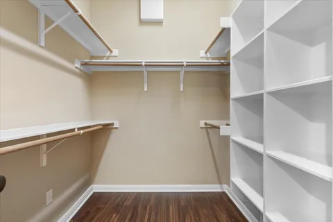 a view of walk in closet with wooden floor