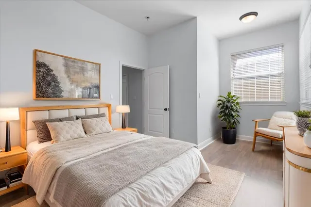 a bedroom with a large bed and a potted plant